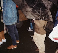 a group of people standing under an umbrella