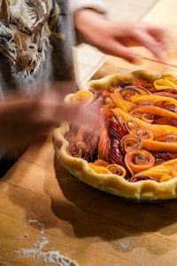 a person is preparing a pie on a table