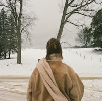 a woman walking down a snowy road