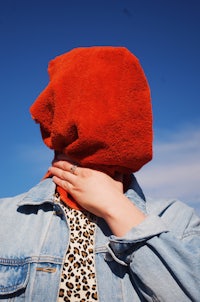 a woman wearing a leopard print jacket and a red towel on her head