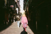 a woman walking down a narrow alley