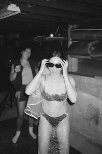 black and white photo of a woman in a bikini in a basement