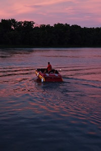 a man in a red boat on the water